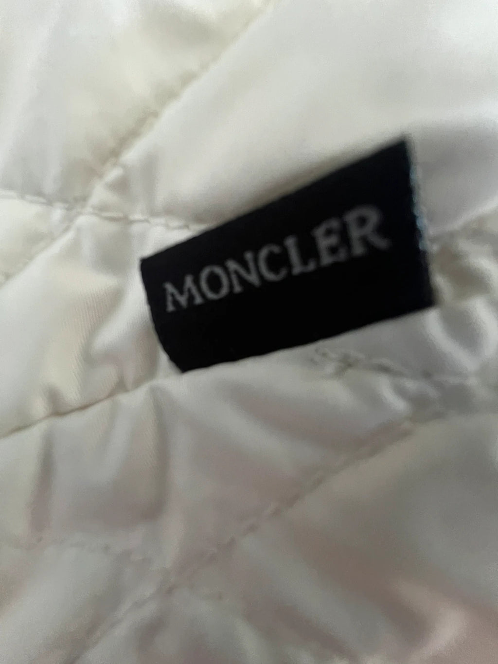 Moncler white gilet with diamond quilted pattern, high collar, and double zipper.