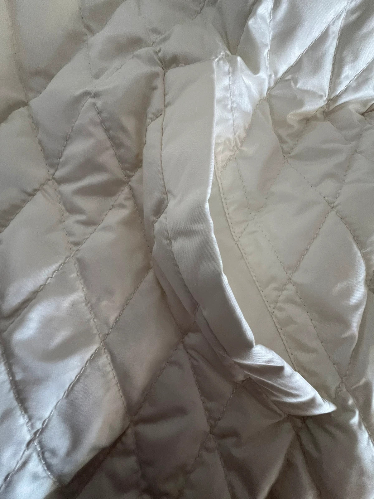 Moncler white gilet with diamond quilted pattern, high collar, and double zipper.