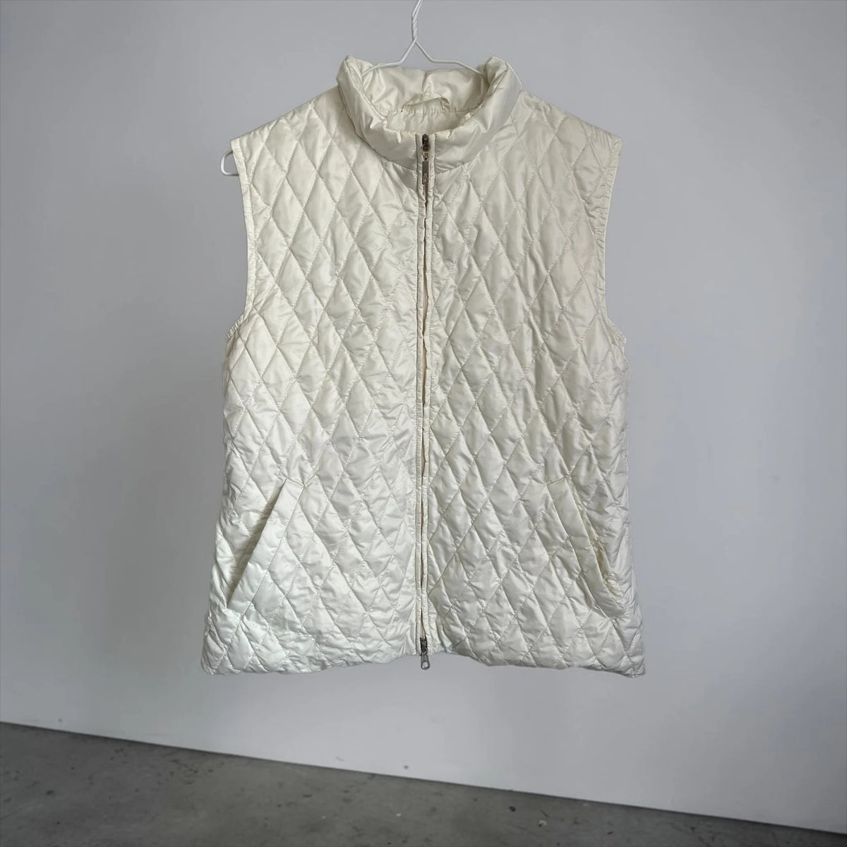 Moncler white gilet with diamond quilted pattern, high collar, and double zipper.
